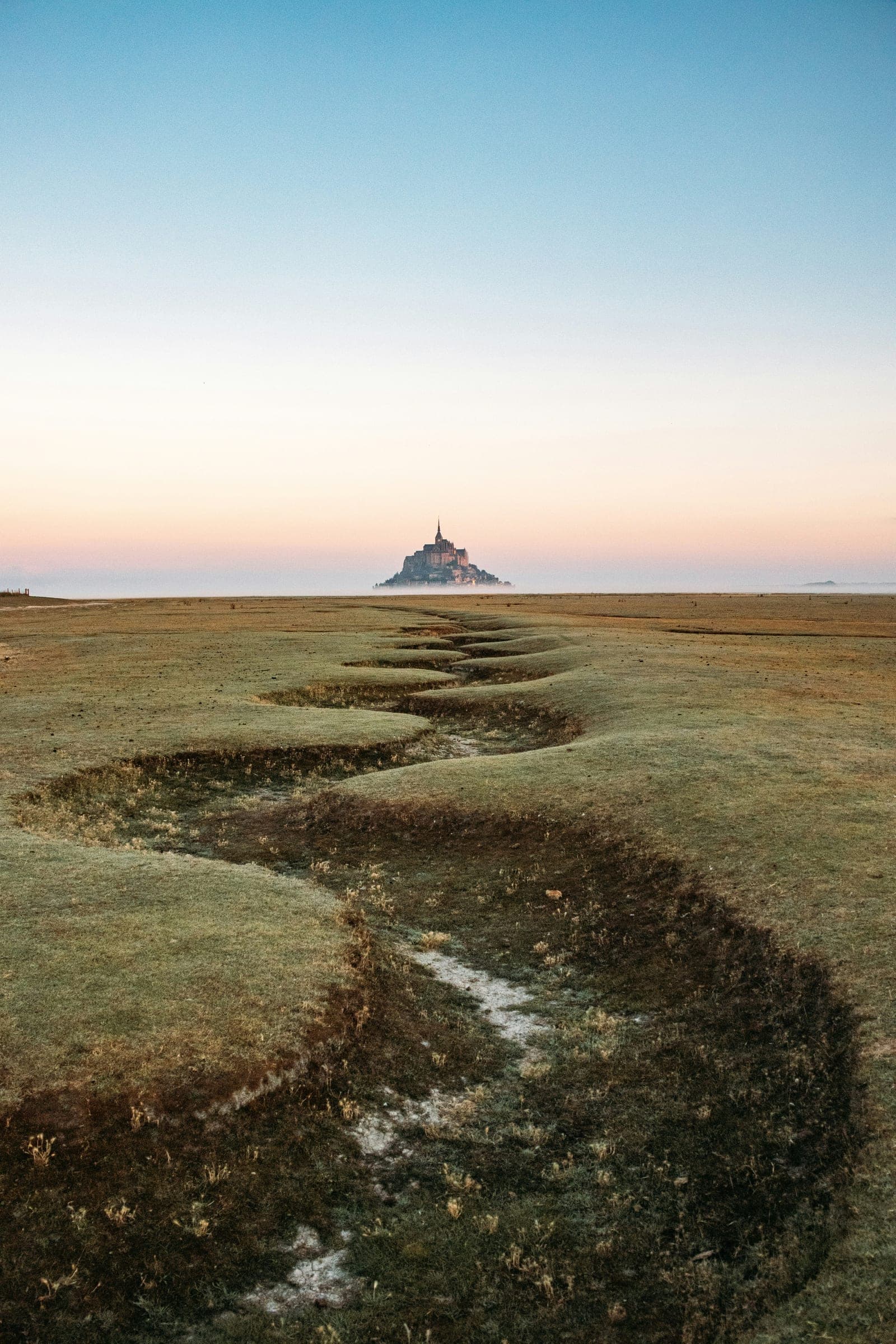 Le Mont-Saint-Michel au lever du jour, vu depuis la baie